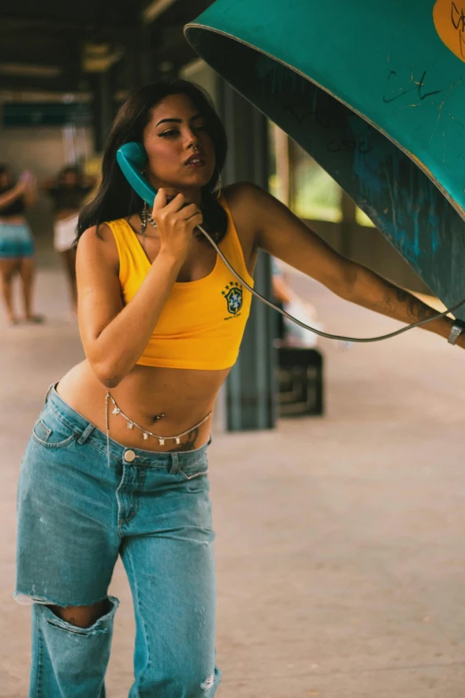 a woman in jeans is holding an umbrella and on her cell phone