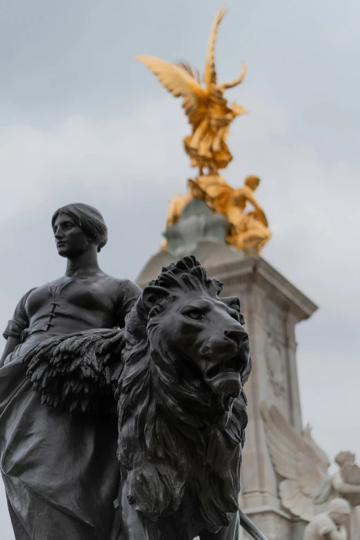 a statue of a man riding a lion next to a gold winged eagle