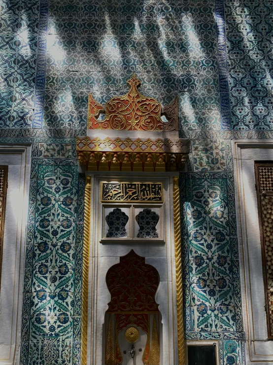 a wall decorated with intricate blue tile and gold accents