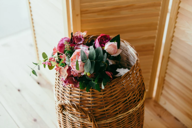 a flower arrangement sitting on top of a table in a basket