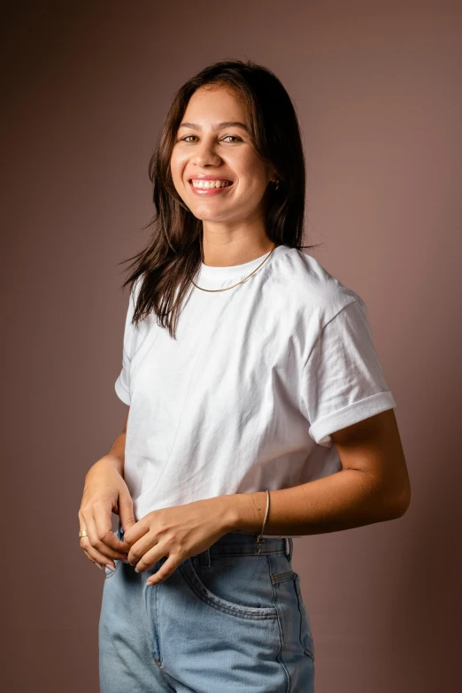 woman in a white shirt with pearls standing and smiling