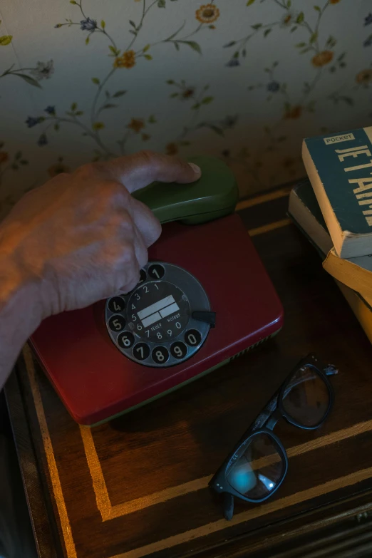 a table that has some books and a telephone on it