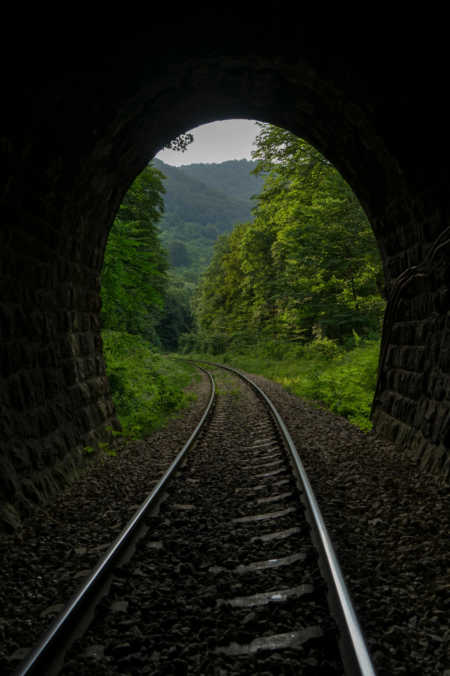 a tunnel with a train track at the end