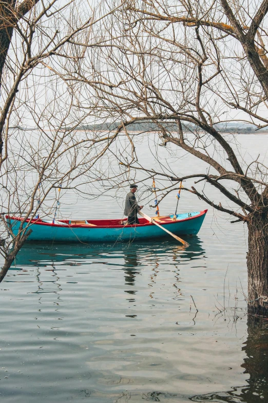 a person in a blue boat floating on top of a lake