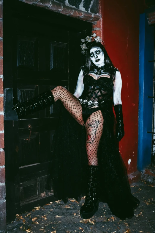 the woman wearing a costume poses in front of a doorway