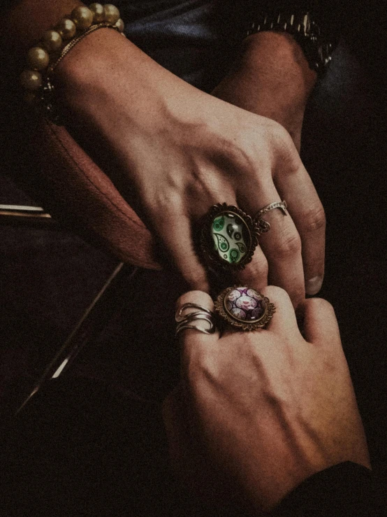 a close - up of two people holding hands with rings