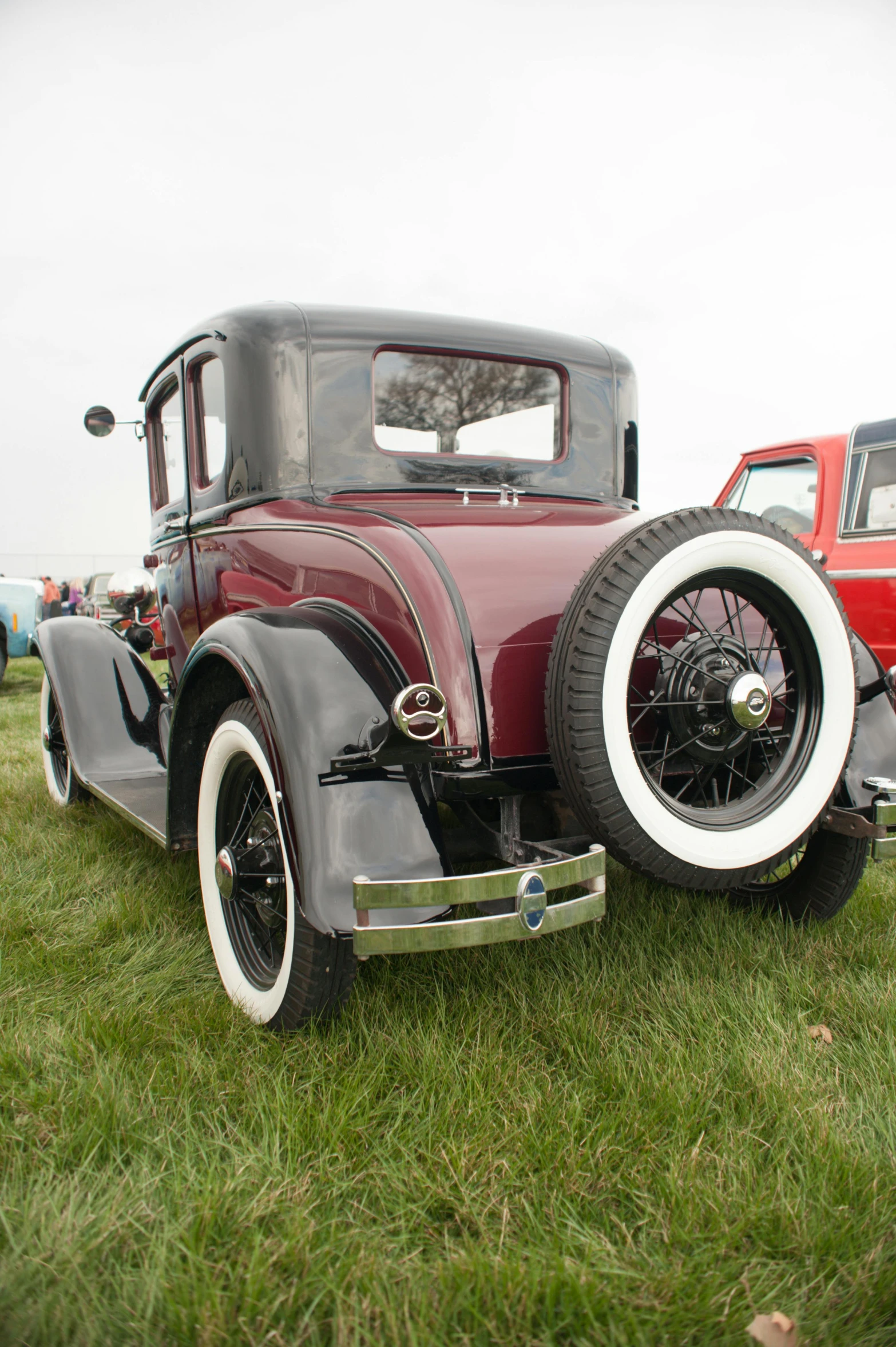 an old style  rod is parked in the grass