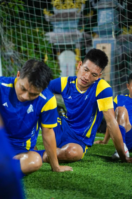 two men in soccer uniforms playing with a soccer ball