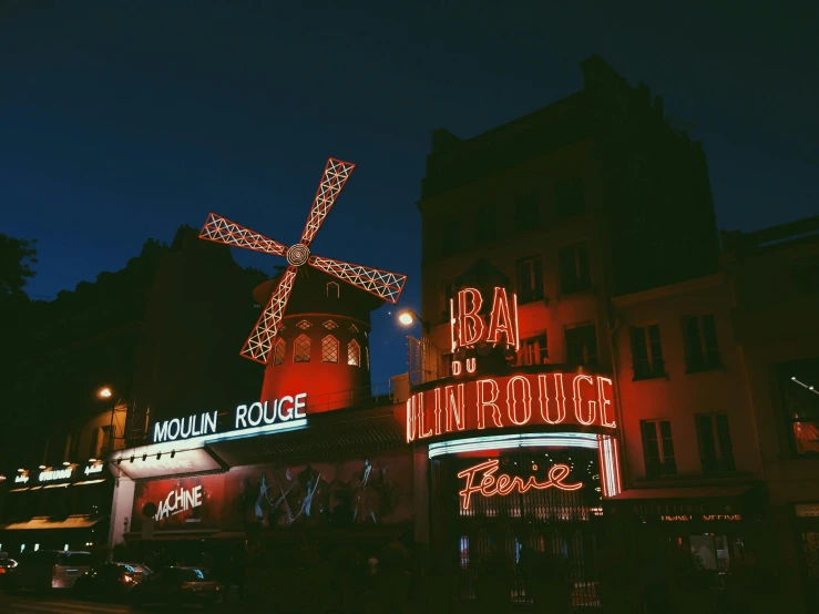 buildings with signs and lights around them lit up at night