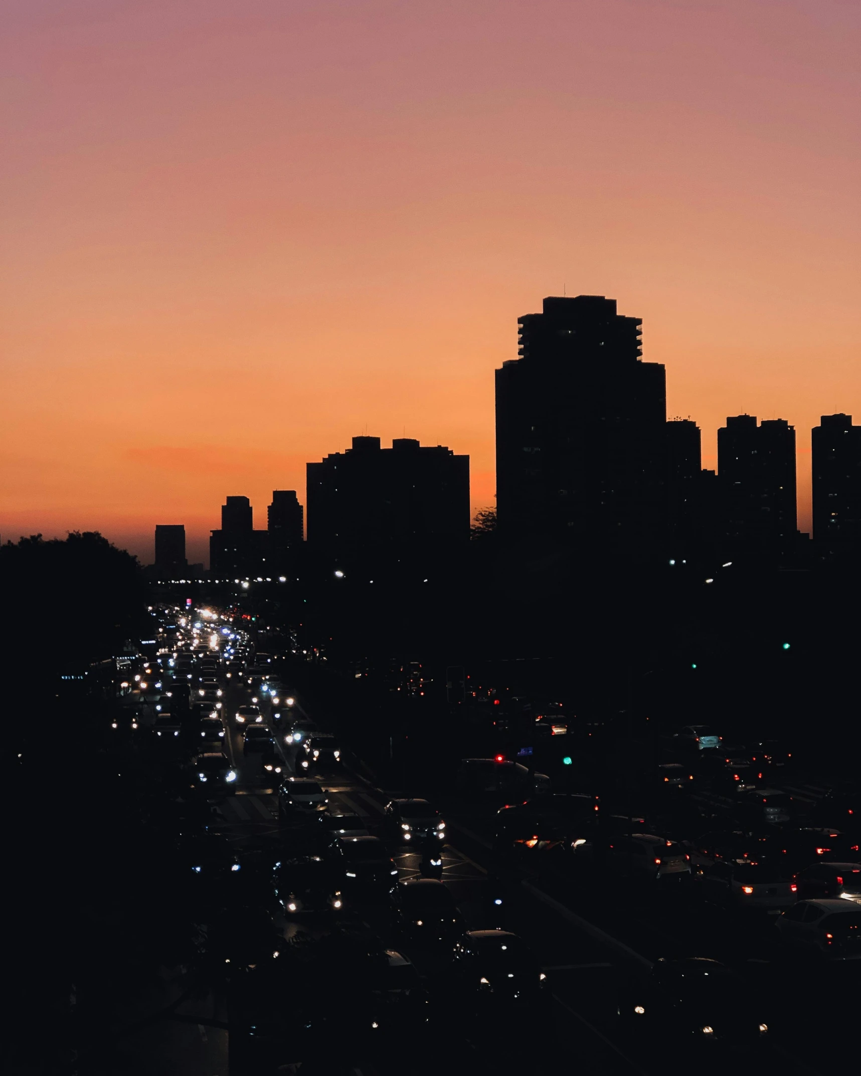 a city skyline at dusk with traffic lights and skyscrs