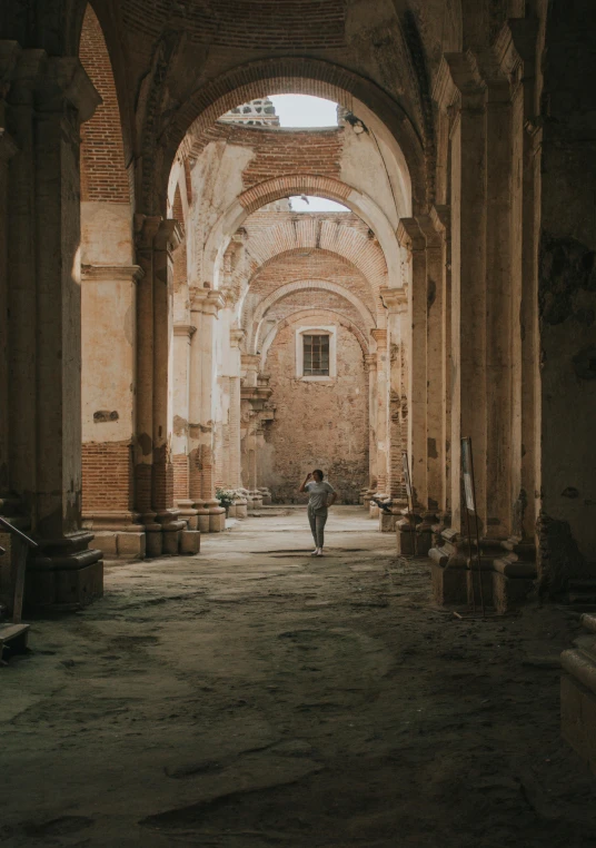 a person walking through a building near a large archway