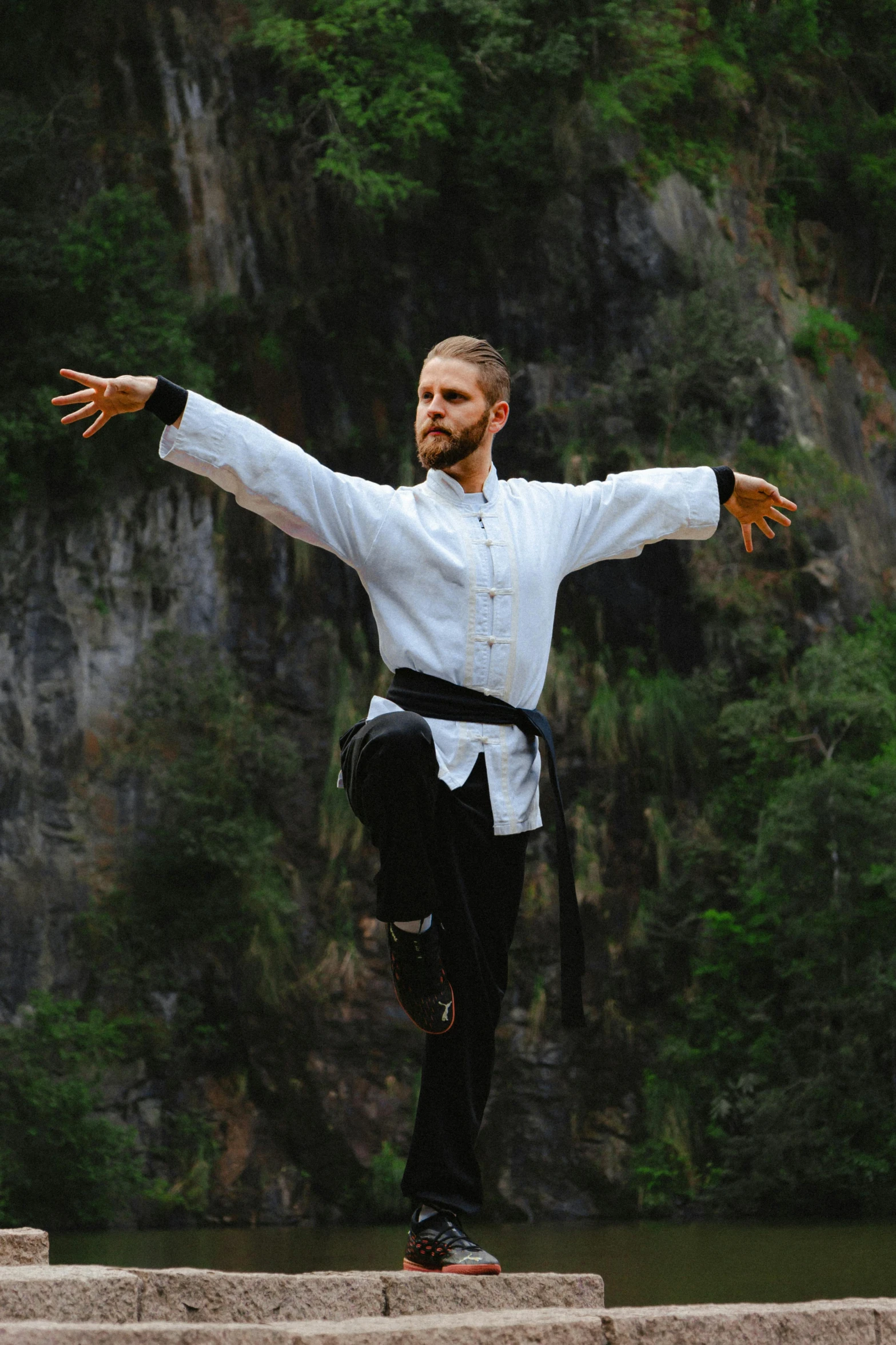 a man in a white shirt doing a kick