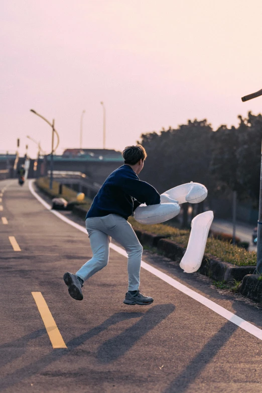 a young man with a kite is on the road