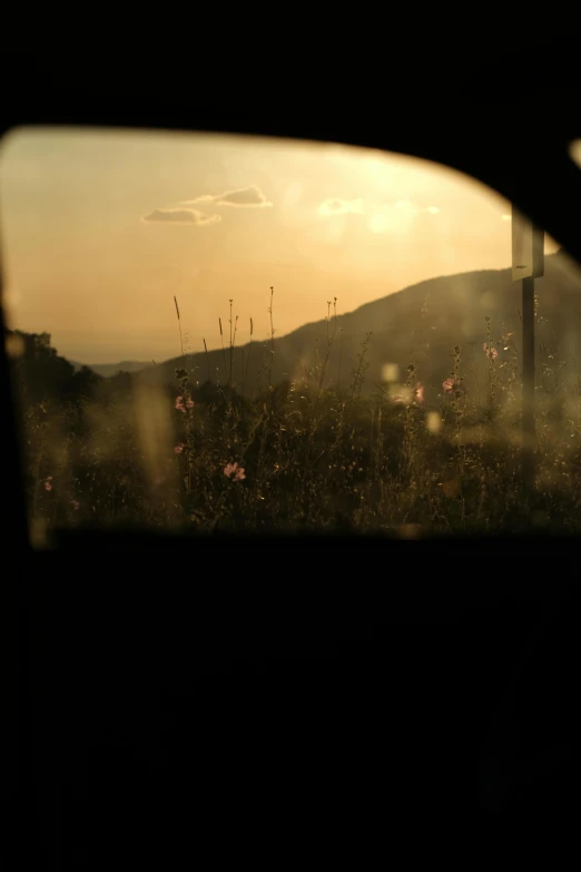 the view of a sun set behind a mountain with a sky background