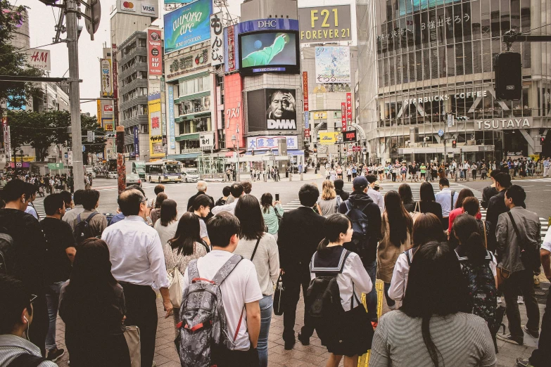 a group of people walking in the street with skyscrs