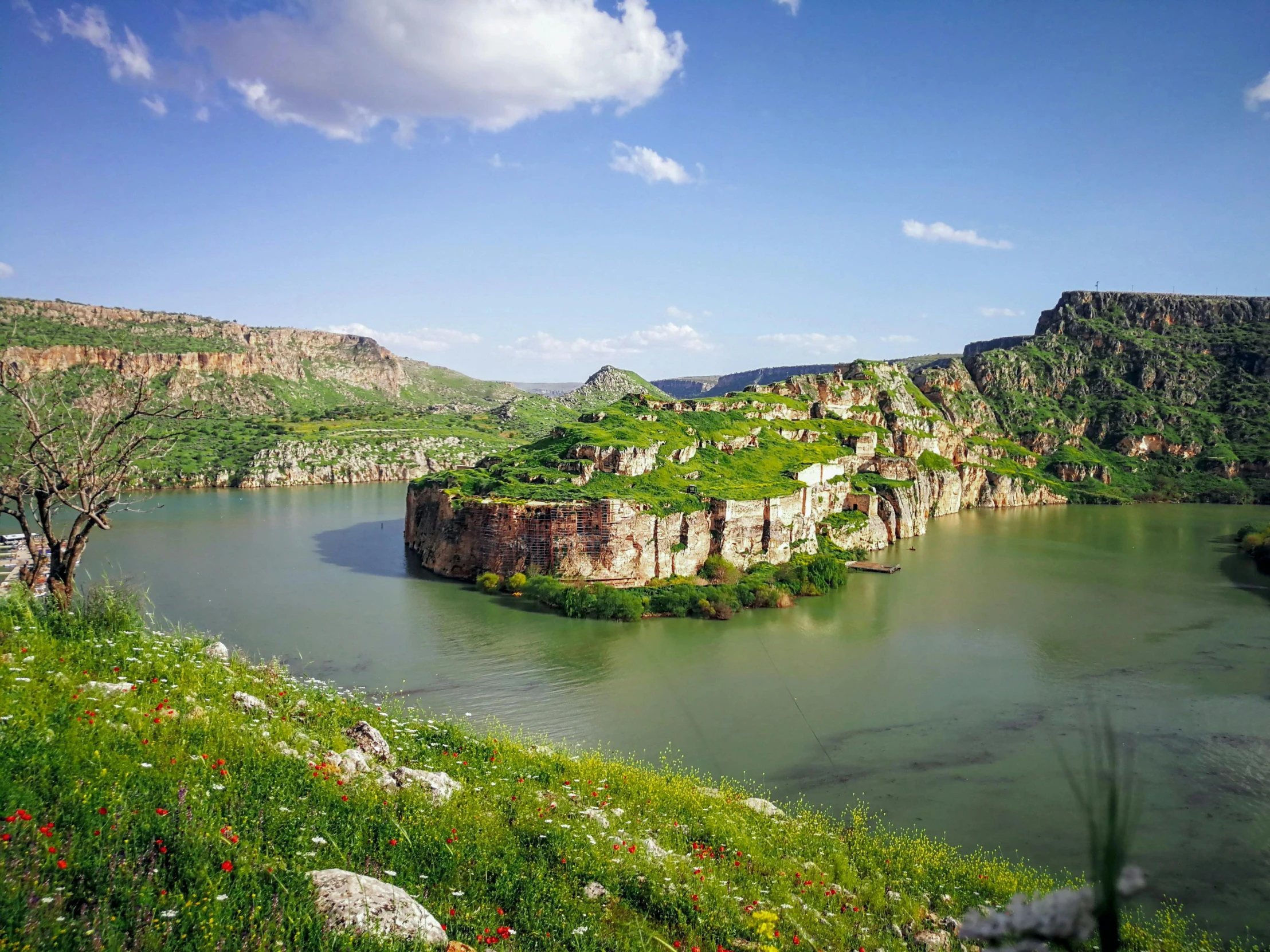 a small island of rocks is surrounded by grassy hills