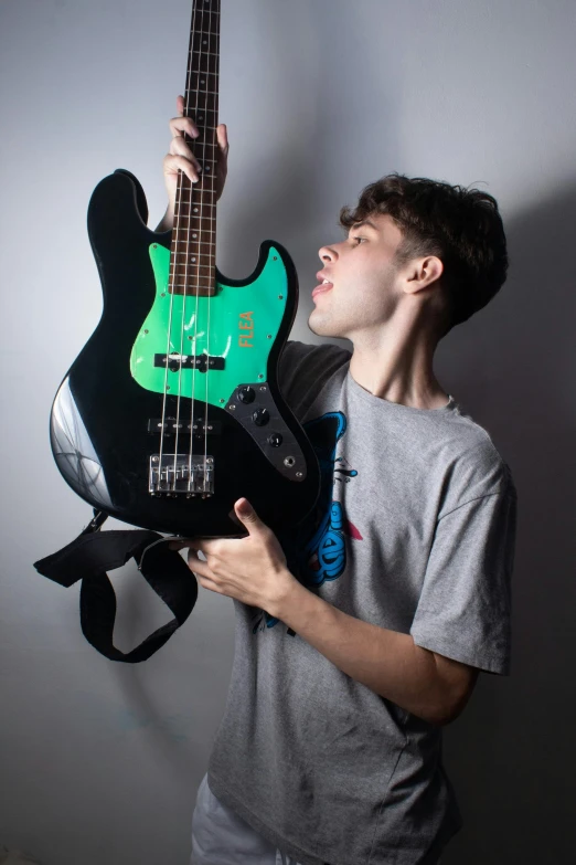 a young man is playing guitar while holding it up