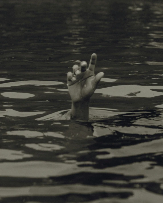 a person with their hand up in the water