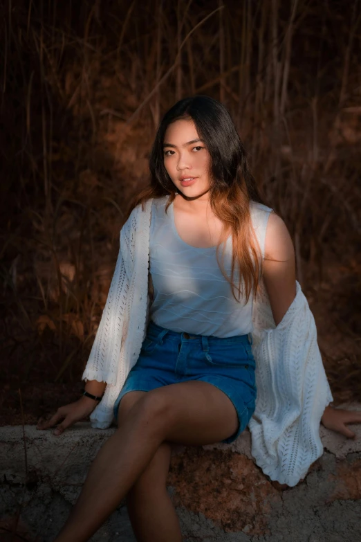 a woman in short shorts is sitting on a wall