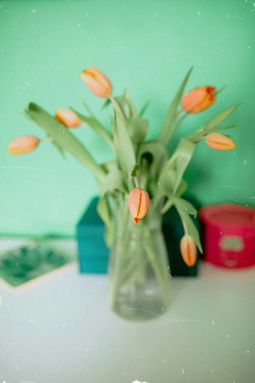 a little vase is holding some small orange flowers