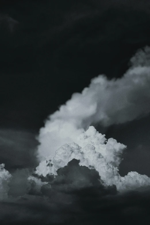 black and white clouds and a jet in the sky