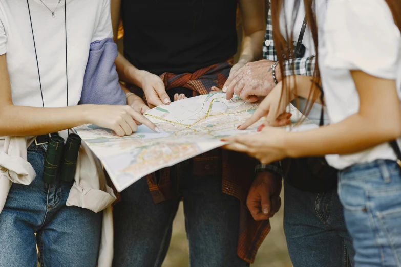 people looking at an old map while holding hands together