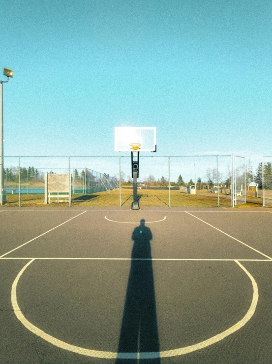 the shadow of a person on a basketball court