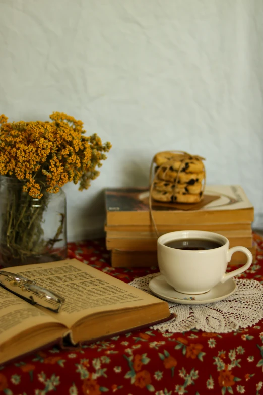 a small cup of coffee sitting next to a stack of books