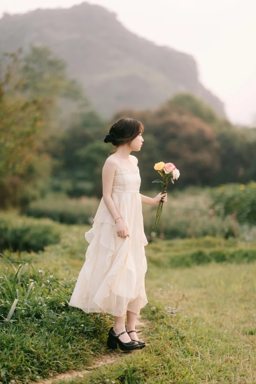 a young woman is holding a flower and wearing sandals