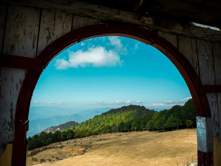 looking through an arched window into a lush hillside