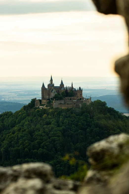 a castle sitting atop a cliff overlooking a valley