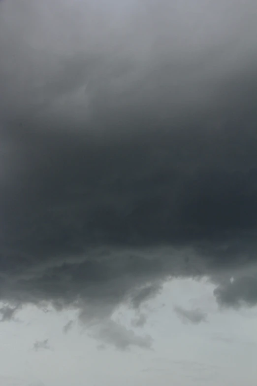 a dark cloudy sky with dark clouds above a field