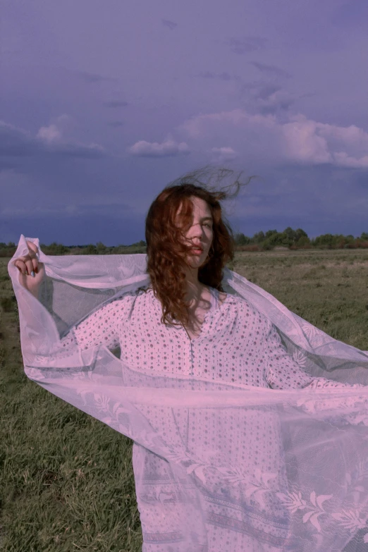 a woman with red hair wearing a white dress in a field