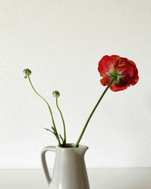 some red flowers are inside a white vase