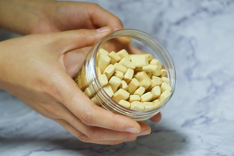 a person grabbing a jar of cheese from the counter