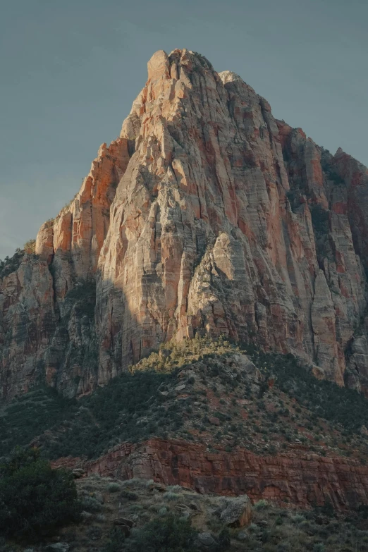 a very tall rocky mountain rising from a desert