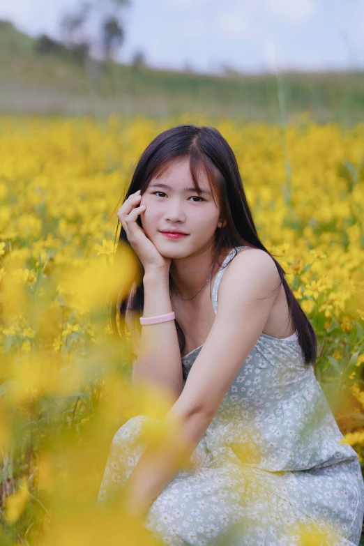 a woman sitting in a field full of yellow flowers