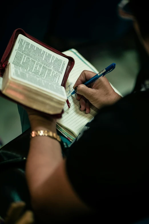 a person writes on an open book