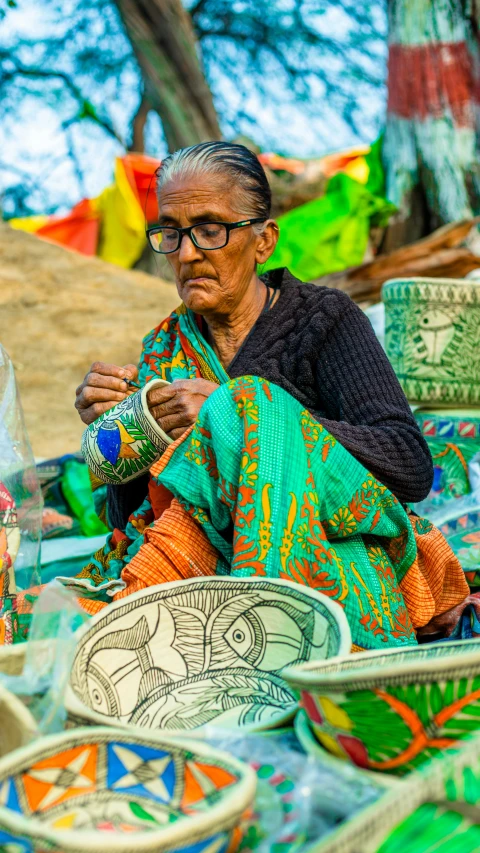 an old woman sewing a fabric at the handicture