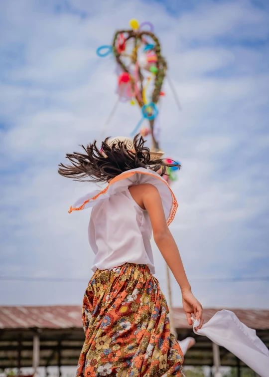 woman walking under a colorful kite while holding her coat