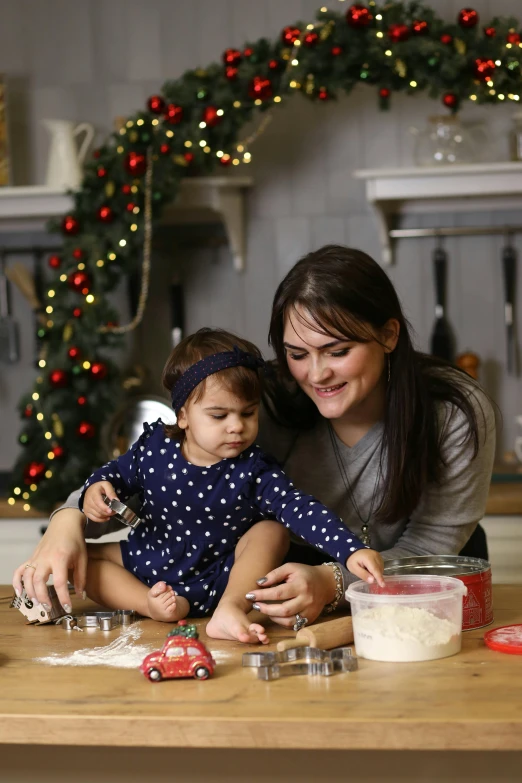 a woman is holding a child while she puts ingredients in a bowl