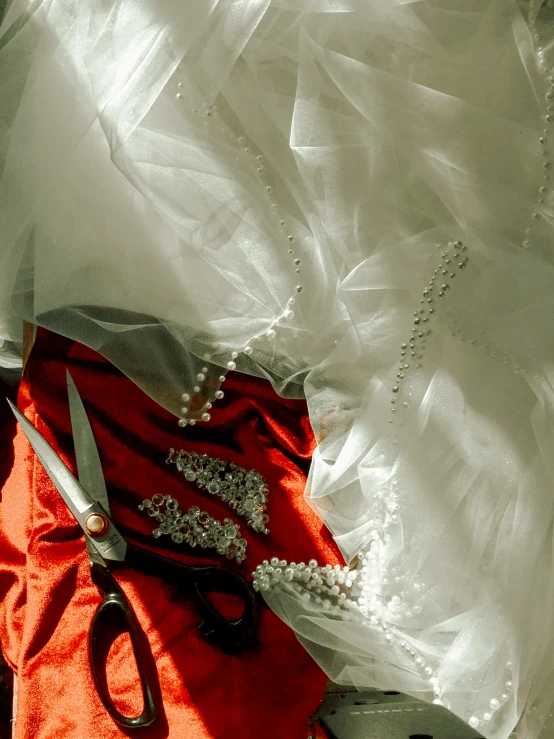 scissors, beads and necklace laying on a white sheet