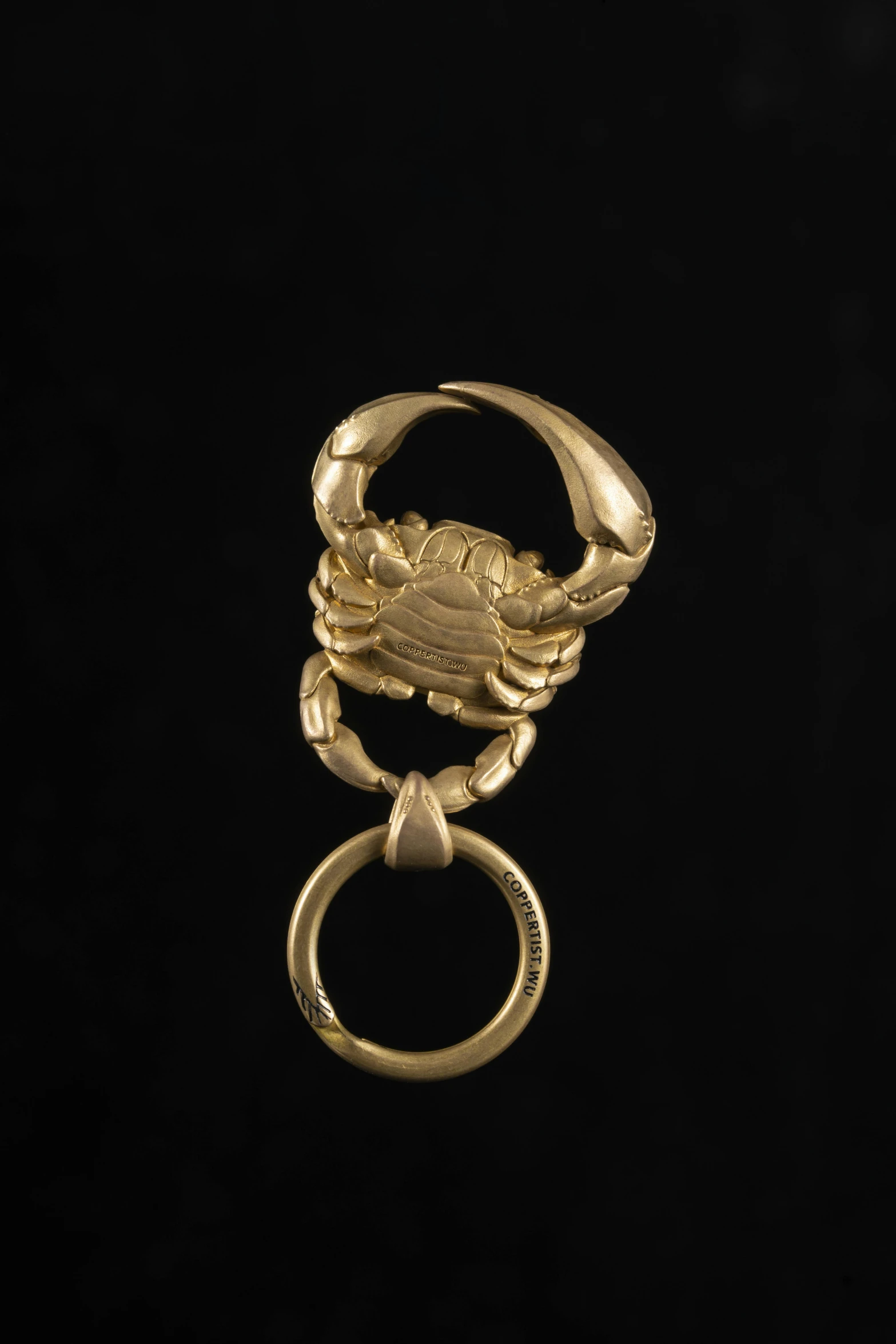 a gold ring with a crab head on it