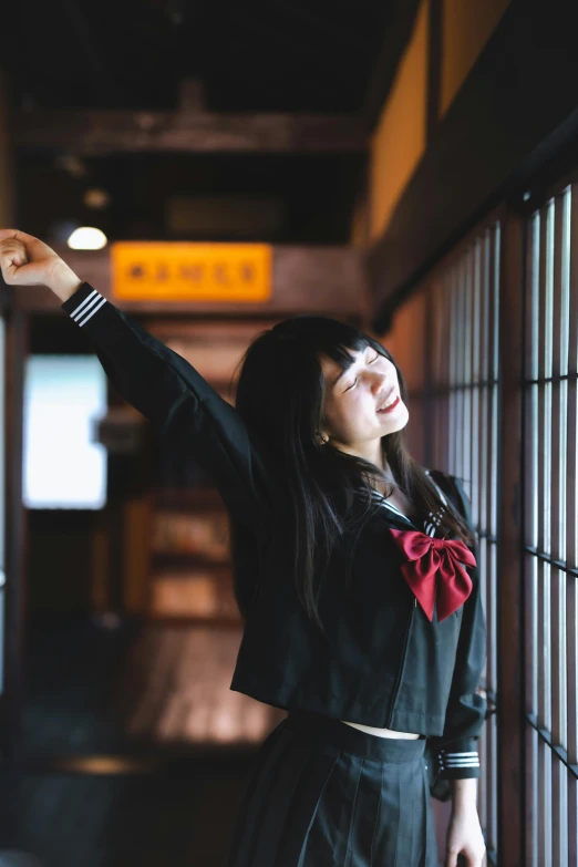 a woman standing on the side of a road next to a window