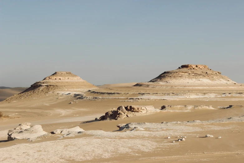 a couple of big desert hill sitting in the middle of a field