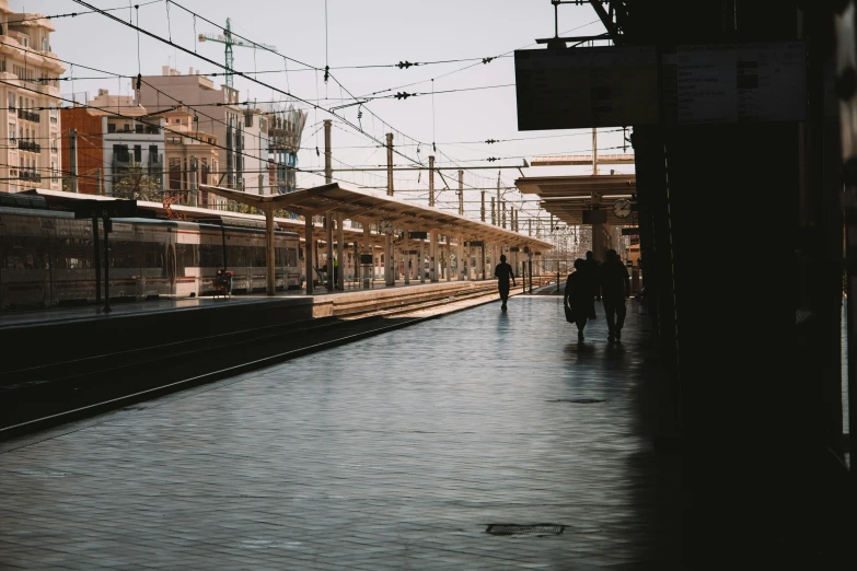 people walking down an open train platform