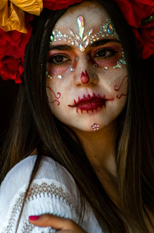 a beautiful woman with sugar on her face and day of the dead make - up