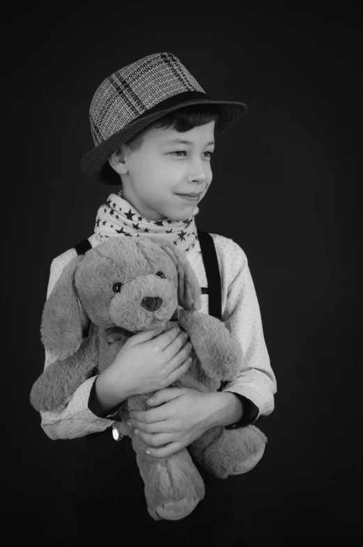 a child standing in the studio holding a stuffed animal