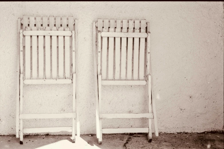 a couple of empty white chairs next to each other