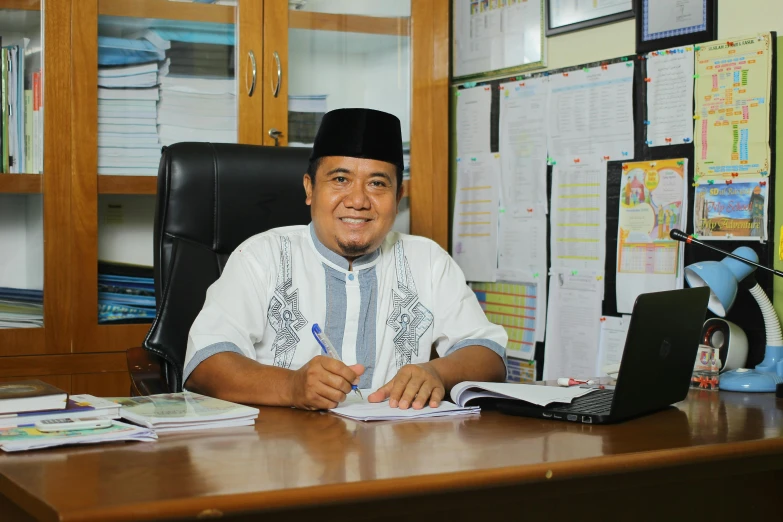 a man sitting at a desk with books and paperwork